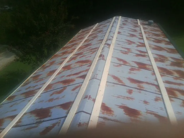 Rusted metal roof panels with new wood purlins before replacement — Storm Damage Roof Repair in Carsonville by Roofing Brothers