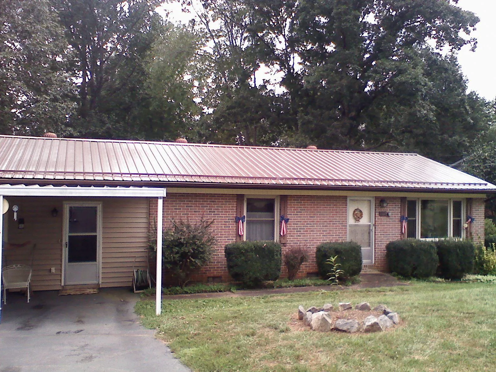 Bronze metal roof and carport on a brick ranch home — Roof Repair work by our crew in Carsonville