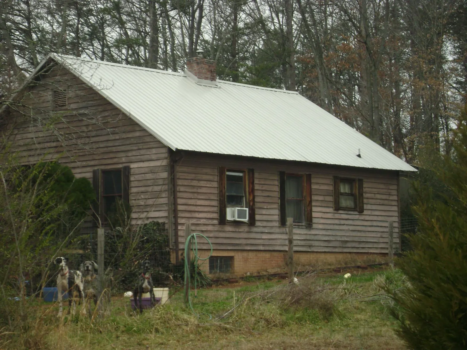 White metal roof on an old wood sided farmhouse, from a Metal Roof Installation job in Carsonville